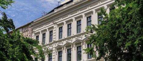 A multi-story building with classical architecture, featuring symmetrical windows and decorative moldings.