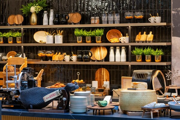 Un espace buffet bien aménagé, avec une variété de plats, d’ustensiles et d’éléments décoratifs disposés sur des étagères.