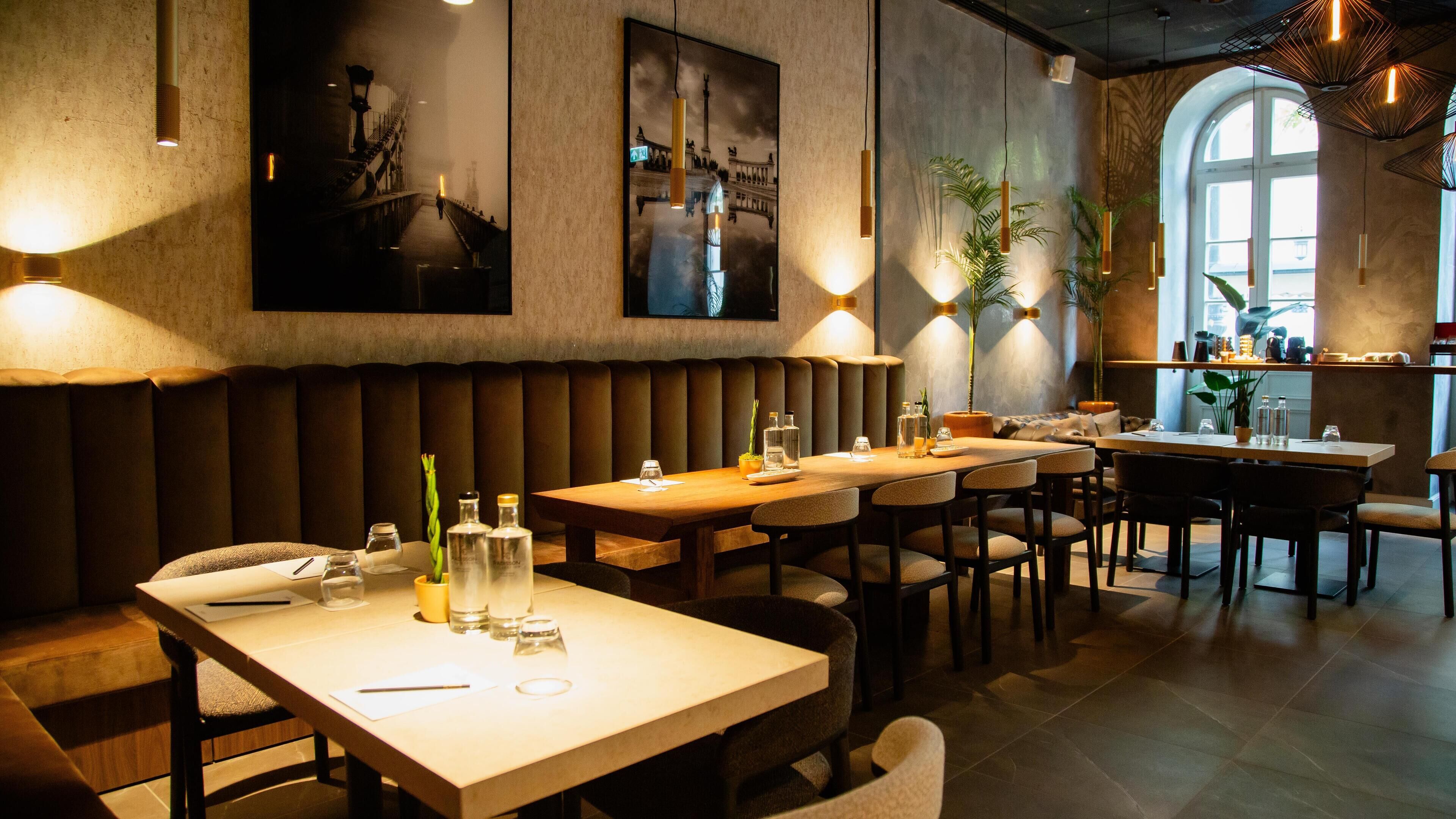 Un interior de restaurante con cabinas, mesas y lámparas colgantes.
