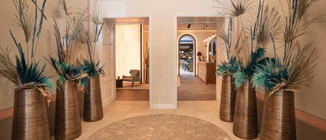 A spacious lobby with tall, textured vases and a large, round carpet.