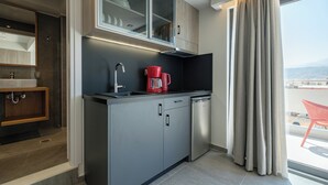 Een moderne keuken met een inbouwvaatwasser, een koffiezetapparaat en een raam met gordijnen.
