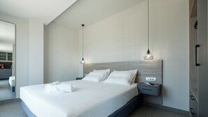 Een moderne hotelkamer met een groot bed, nachtkastjes en hanglampen.