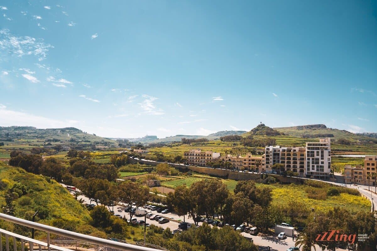 A view of a residential area with buildings, a parking lot, and greenery.