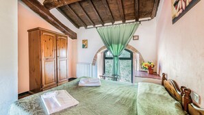 A bedroom with a bed, wooden wardrobe, and a window with a view of greenery. - Beautiful home in Dicomano with WiFi (Dicomano)