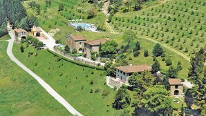 An aerial view of a rural estate with stone buildings, a swimming pool, and terraced fields. - Beautiful home in Dicomano with WiFi (Dicomano)