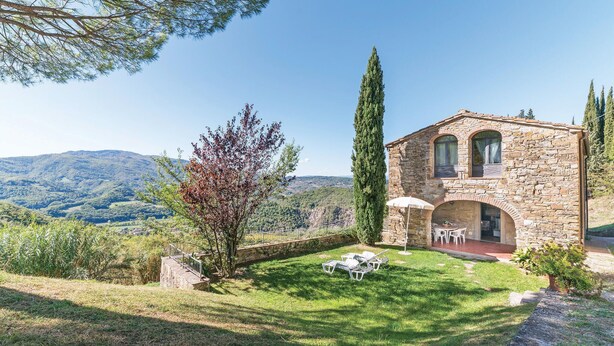 A stone building with a patio and outdoor seating area, surrounded by greenery and hills. - Beautiful home in Dicomano with WiFi (Dicomano)