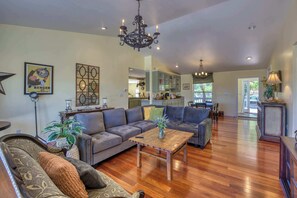 A spacious living room with a large sectional sofa, a wooden coffee table, and a chandelier. - Napa Vineyard with Stunning Views By Allevo Homes (Napa)