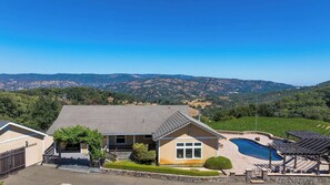 A residential property with a swimming pool, a patio area, and a view of the surrounding hills. - Napa Vineyard with Stunning Views By Allevo Homes (Napa)