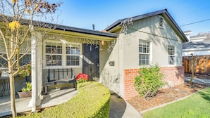 Ett tvåvåningshus med en veranda på framsidan, en liten trädgård och en grund av tegelsten.