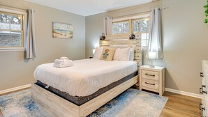 A bedroom with a bed, bedside table, and a window with curtains. - 4 Mi to Savannah: Home w/ Gazebo & Seasonal Pool! (Garden City)