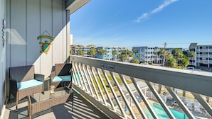 A balcony with wicker furniture, a welcome sign, and a sign indicating the direction to the beach. - Walk to Beach: Top-floor Condo in Murrells Inlet (Murrells Inlet)