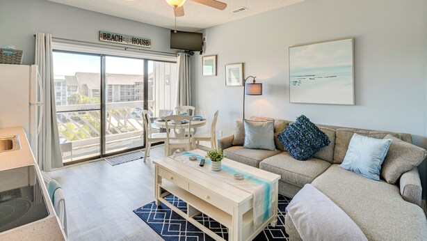 A modern living room with a sofa, coffee table, and a ceiling fan. - Walk to Beach: Top-floor Condo in Murrells Inlet (Murrells Inlet)