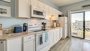 A modern kitchen with white cabinets, a microwave, a toaster, and a coffee maker. - Walk to Beach: Top-floor Condo in Murrells Inlet (Murrells Inlet)
