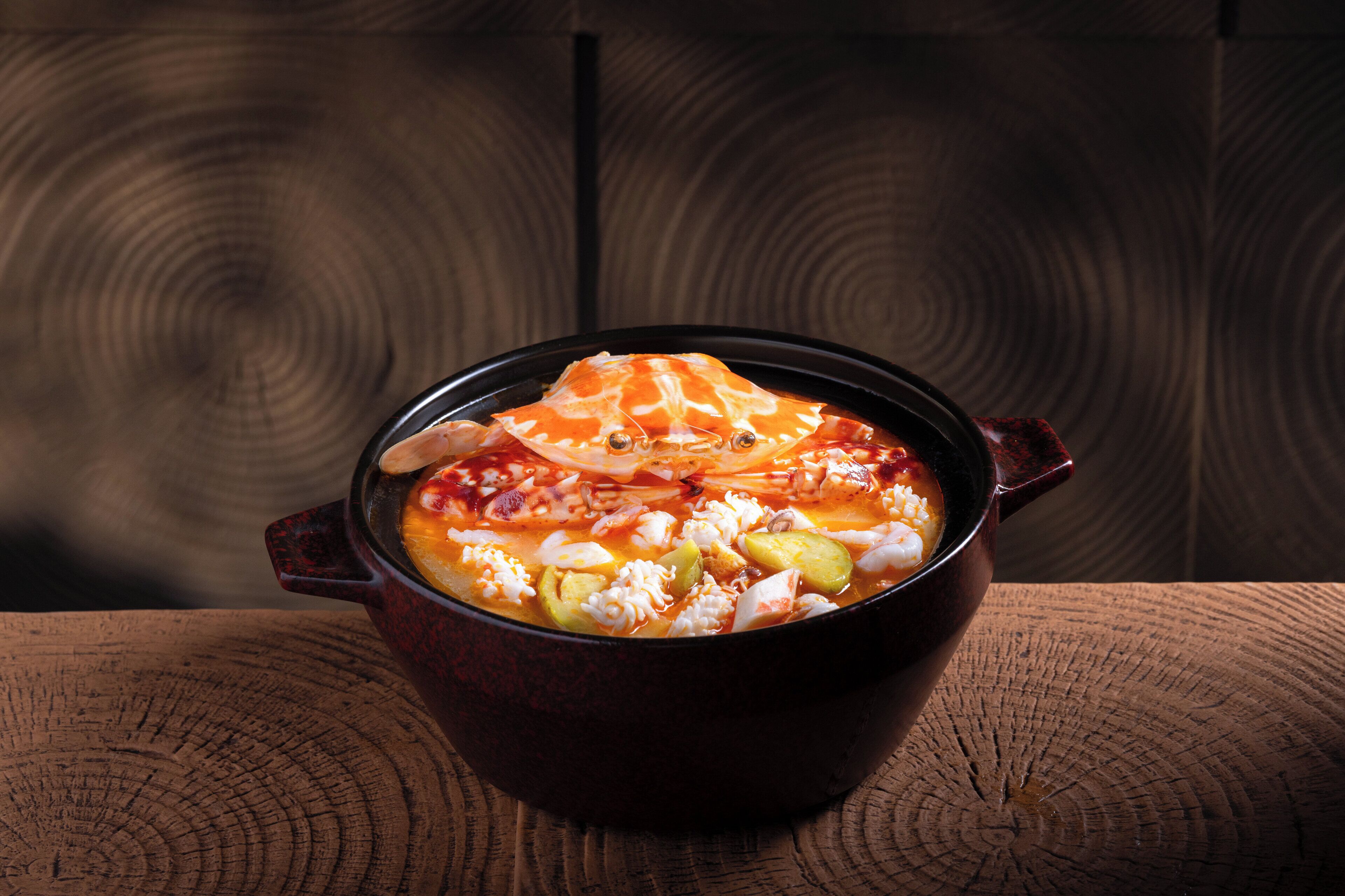 A bowl of soup on a wooden table.