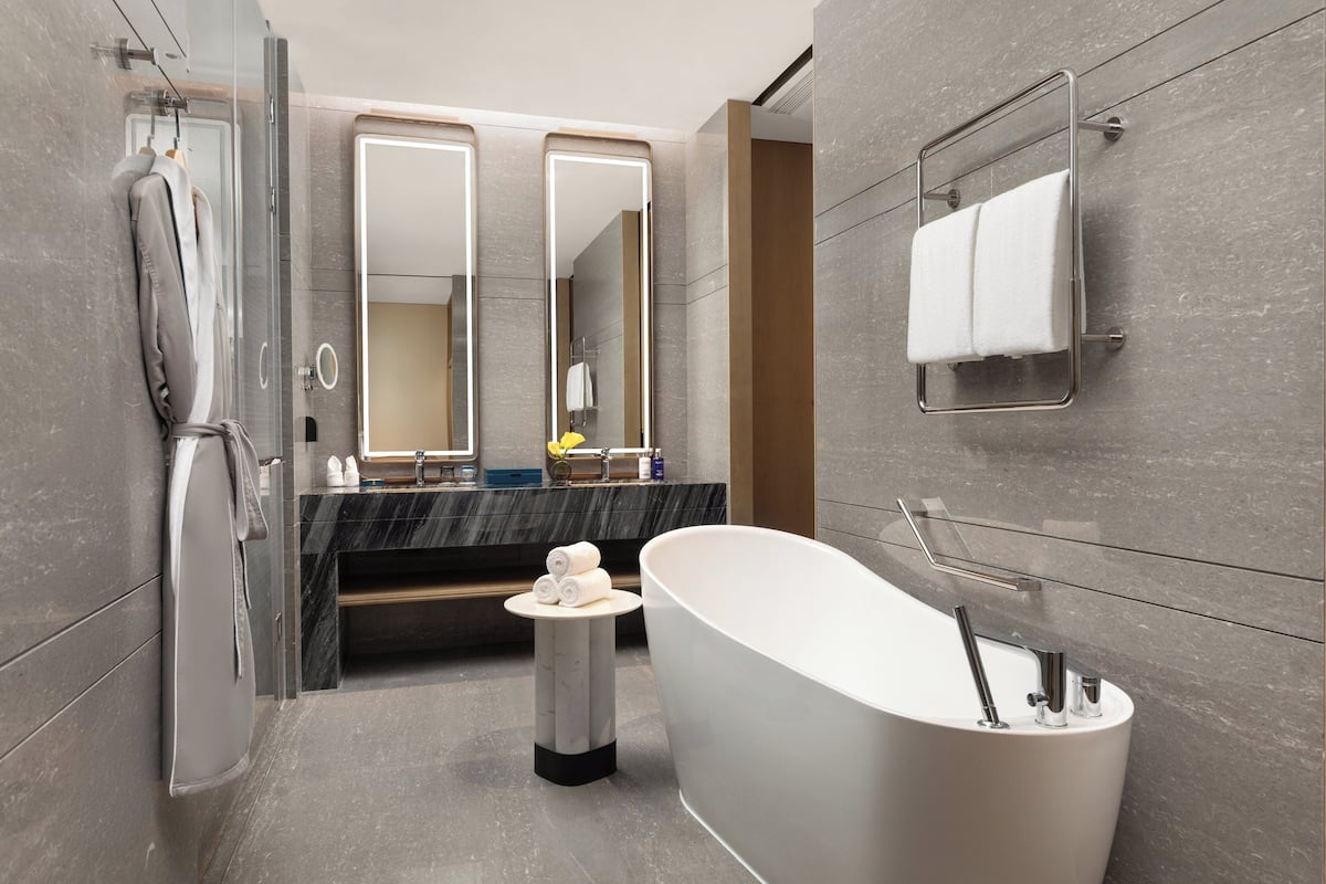 A modern bathroom with a freestanding bathtub, a glass shower enclosure, and a vanity with a mirror.