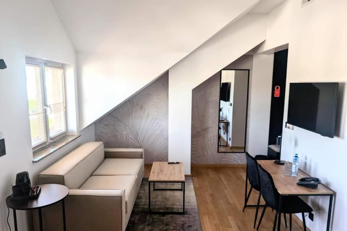 Una sala de estar moderna con un sofá, una mesa de centro y un comedor con una mesa y sillas.