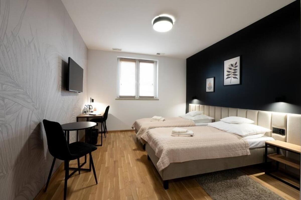 Una habitación de hotel moderna con dos camas, un escritorio y una silla.