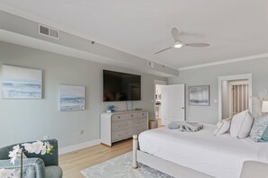A bedroom with a bed, a dresser, a television, and artwork on the walls. - Grand Playa | Gulf Front! | Private Beach! | Pool! (Santa Rosa Beach)