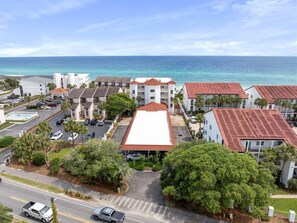 A coastal hotel with a parking lot, a swimming pool, and a view of the ocean. - Grand Playa | Gulf Front! | Private Beach! | Pool! (Santa Rosa Beach)