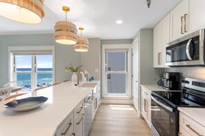 A modern kitchen with a large island, stainless steel appliances, and pendant lighting. - Grand Playa | Gulf Front! | Private Beach! | Pool! (Santa Rosa Beach)