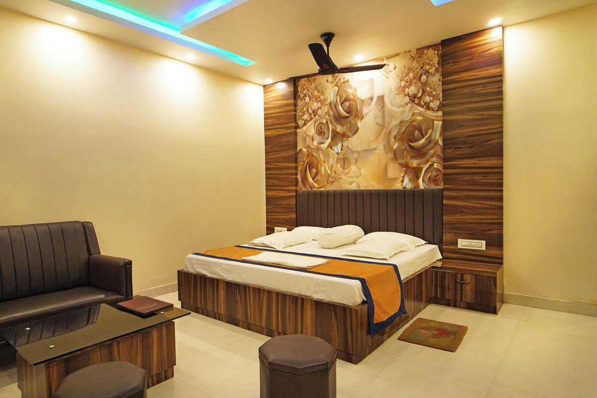A modern hotel room with a bed, a sofa, and a small table.