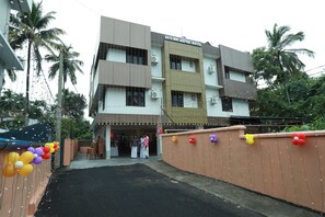 A multi-story hotel with a flat facade, air conditioning units, and a gated entrance. - Gateway Airport Hotel (Iritty)
