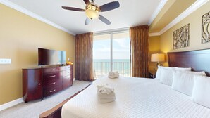 A hotel room with a bed, a TV, a ceiling fan, and a view of the ocean. - Tidewater 509 -Gulf front - Amazing views! (Panama City Beach)