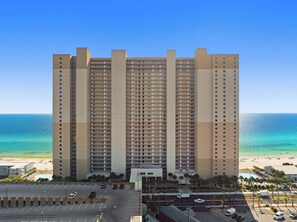 A high-rise hotel with multiple balconies, a parking lot, and a beach view. - Tidewater 509 -Gulf front - Amazing views! (Panama City Beach)