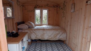 Une petite pièce agréable et confortable, avec un lit, un bureau et un tapis à motifs.