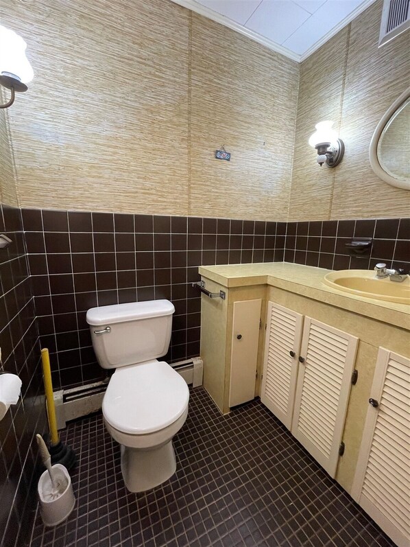 Un baño con inodoro, lavamanos y espejo.