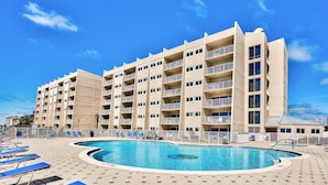 A multi-story hotel with a swimming pool and sun loungers. - Beach House 301a 2 Bedroom Condo (Miramar Beach)