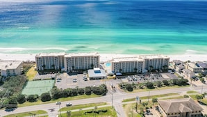 A beachfront hotel with multiple buildings, a parking lot, and a tennis court. - Beach House 301a 2 Bedroom Condo (Miramar Beach)