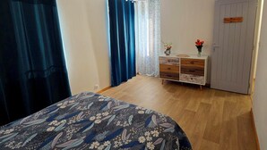 A bedroom with a bed, a dresser, a door, and a ceiling light. - RENOVATED HOUSE SLEEPS 6 - SPACIOUS LIVING ROOM - WI-FI - FREE PARKING (Arthun)