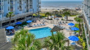 A hotel with a pool, beach view, and outdoor seating area. - Seascape 1313 2 Bedroom Condo (Galveston)