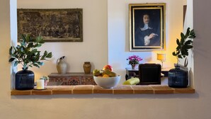 A living room with a fireplace, a large painting, a framed portrait, and a bowl of fruit on the mantel. - Walnut House (Toscana)