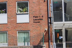 Un bâtiment en briques sur lequel on peut lire une plaque indiquant : « Appartements 1 à 8, immeuble Lascelles ».