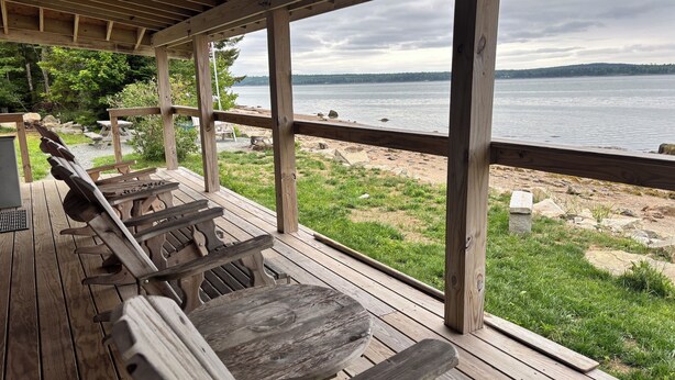 A wooden deck with benches overlooking a lake.