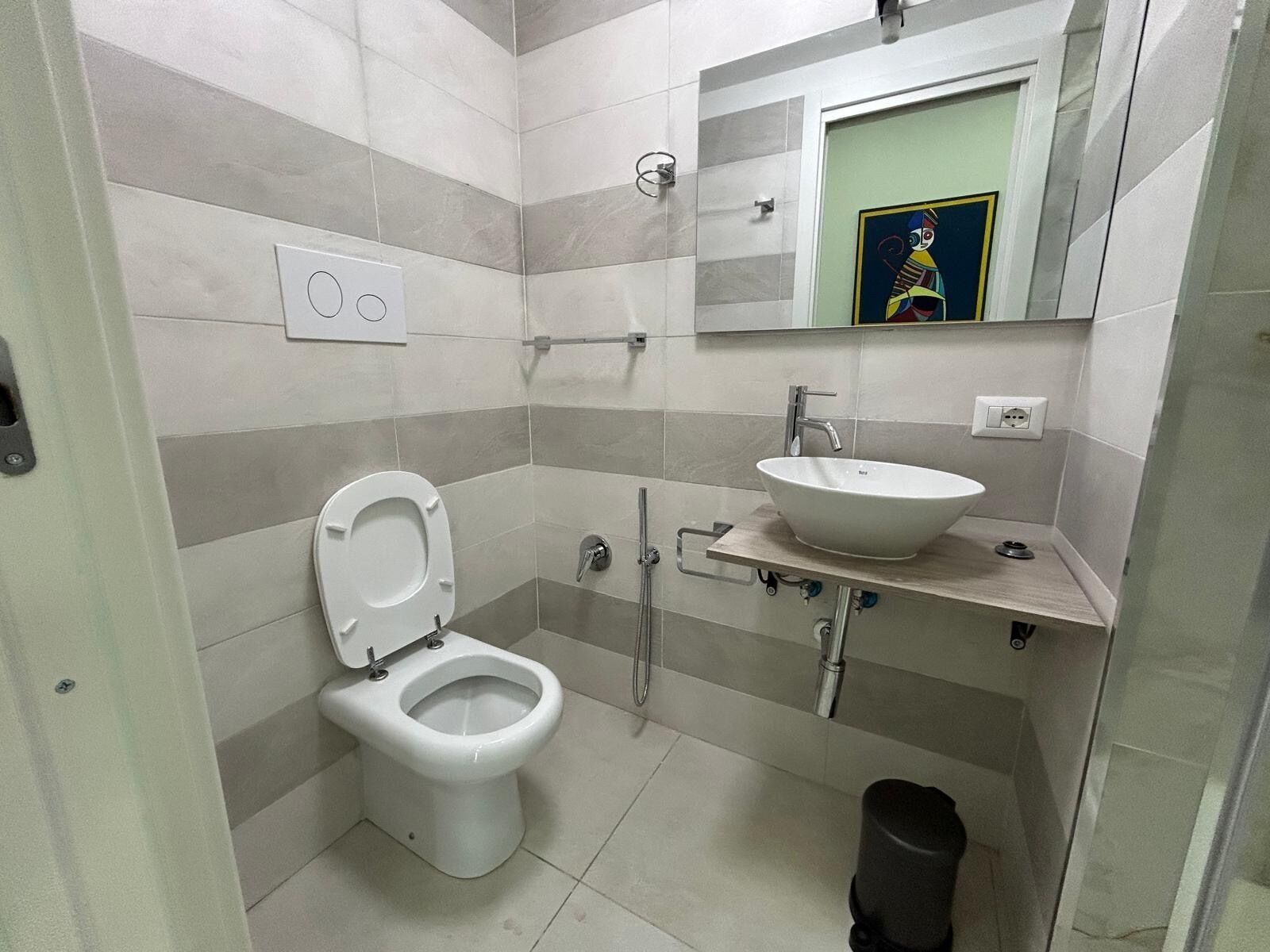 Une salle de bain moderne équipée de toilettes, d’un lavabo et d’une douche.