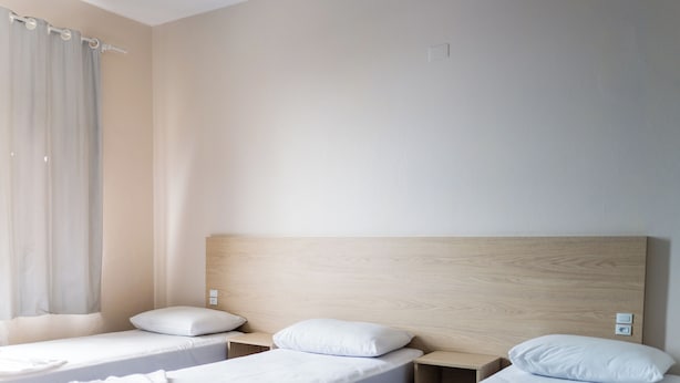 A hotel room with two single beds, a wooden headboard, a small bedside table, and a window with curtains. - Ok Inn Hotel Florianópolis (Florianópolis)