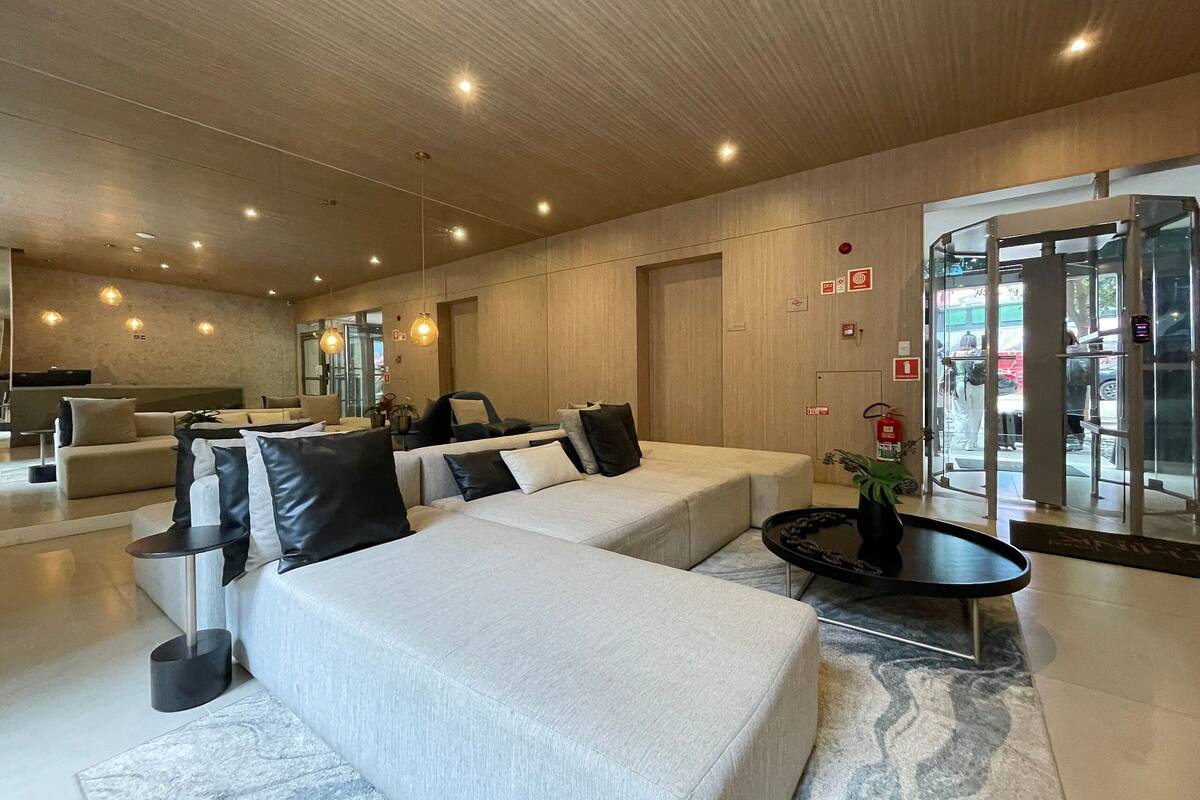 Een moderne lobby met banken, een salontafel en een draaideur.