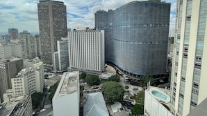 Zona urbana con edificios altos y arquitectura moderna, incluyendo un edificio de vidrio curvo y un rascacielos rectangular.