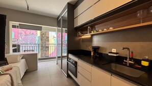 Una cocina moderna con horno empotrado, cafetera y lavabo.