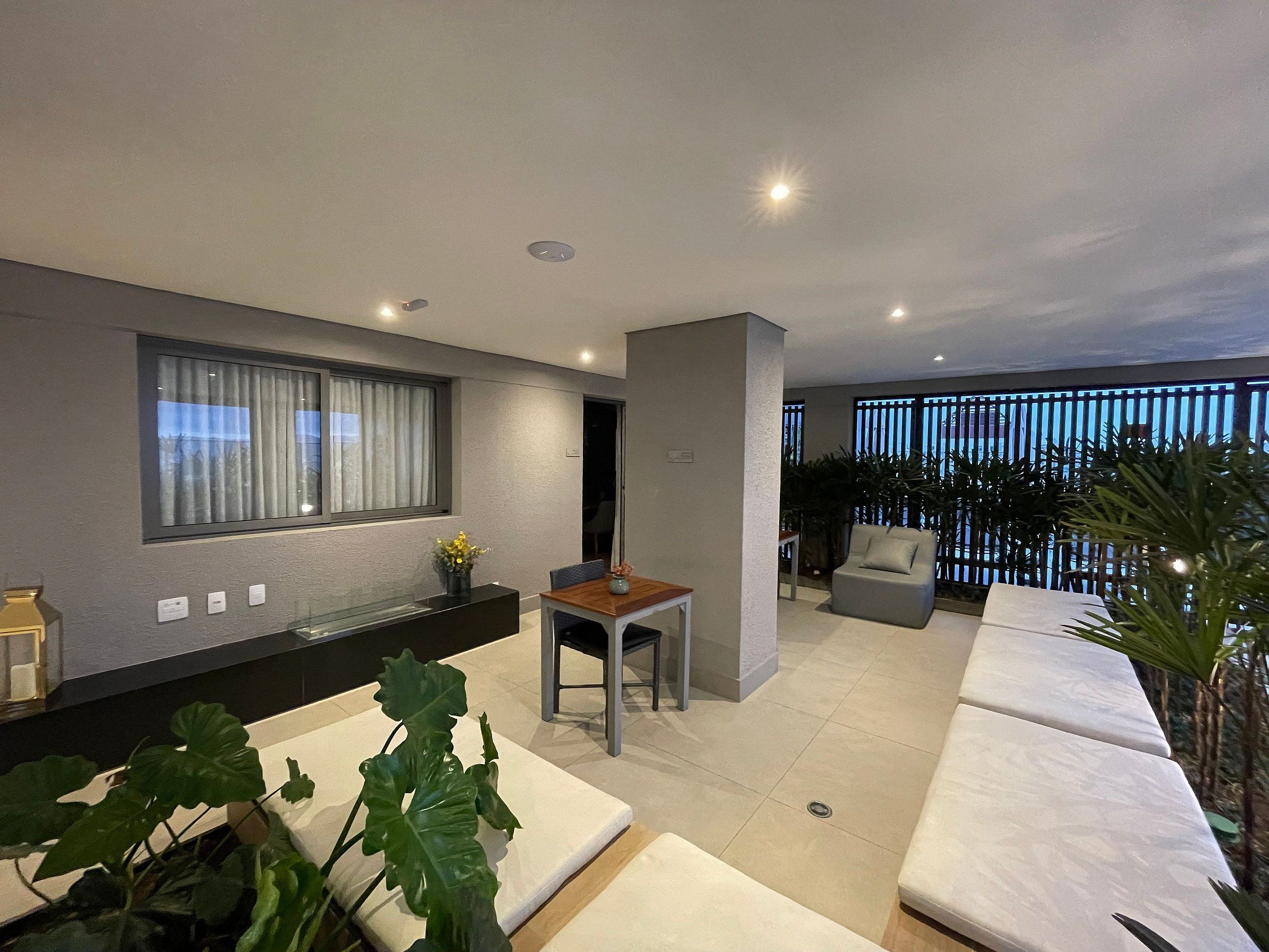 A modern living room with a sofa, a dining table, and a large window.