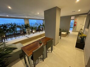 Un intérieur moderne comprenant un coin repas, un espace salon avec vue et un couloir menant à une sortie.