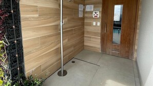 Een moderne badkamer met een douche, houten wanden en een deur met uitzicht.