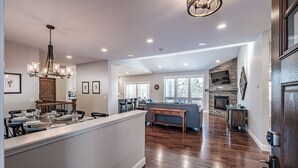 A spacious kitchen with a central island, wooden flooring, and a modern chandelier. - Beautiful home located on the coveted Paradise Road in Bethel Maine (Bethel)