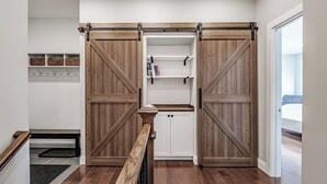 A room with a wooden sliding door closet, a bench, and a small shelf with books. - Beautiful home located on the coveted Paradise Road in Bethel Maine (Bethel)