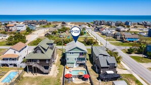 Un quartiere residenziale con case, una piscina e vista sulla spiaggia.