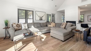 A spacious living room with a sectional sofa, a coffee table, and a fireplace. - Inspect2Sea: Pool, Hot Tub | Walk to Downtown Duck (Duck)