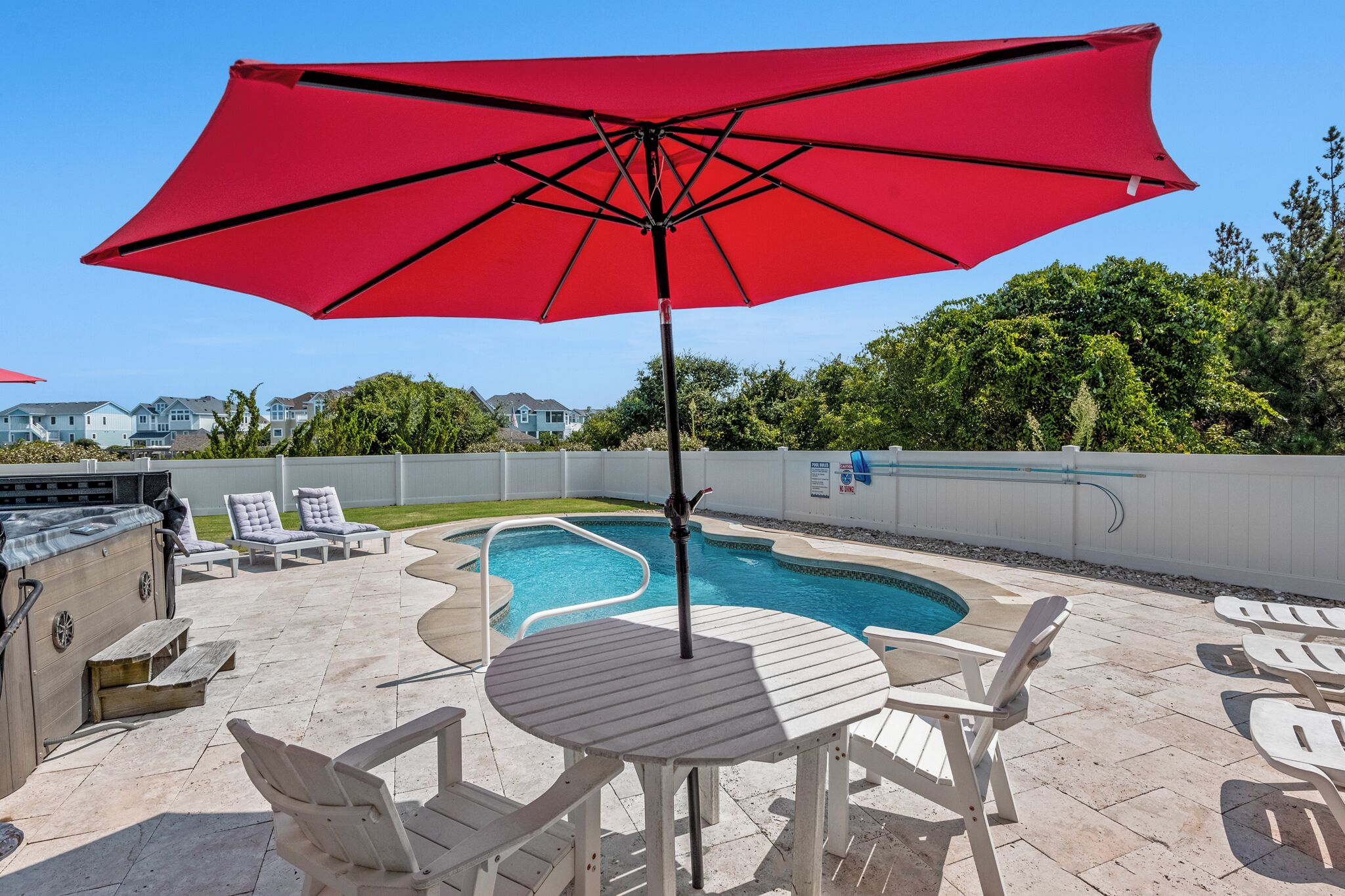 A backyard with a swimming pool, outdoor seating, and a barbecue area.